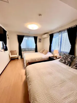 a hotel room with three beds and windows at Dragon\u4e09\u5c42\u522b\u5885 \u65b0\u5bbf \u6da9\u8c37 \u4e0a\u91ce\u5546\u5708 \u5c71\u624b\u7ebf\u8f66\u7ad98\u5206\u949f \u4ea4\u901a\u4fbf\u5229 in Tokyo