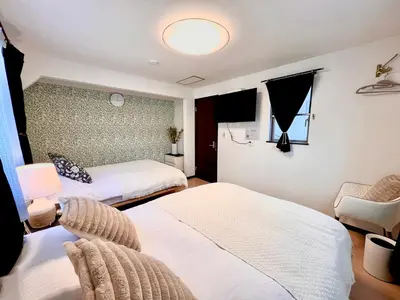 a hotel room with two beds and a chair at Dragon\u4e09\u5c42\u522b\u5885 \u65b0\u5bbf \u6da9\u8c37 \u4e0a\u91ce\u5546\u5708 \u5c71\u624b\u7ebf\u8f66\u7ad98\u5206\u949f \u4ea4\u901a\u4fbf\u5229 in Tokyo