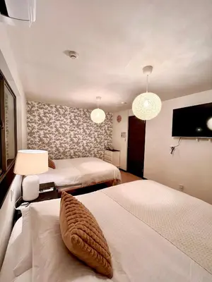 a hotel room with two beds and a flat screen tv at Dragon\u4e09\u5c42\u522b\u5885 \u65b0\u5bbf \u6da9\u8c37 \u4e0a\u91ce\u5546\u5708 \u5c71\u624b\u7ebf\u8f66\u7ad98\u5206\u949f \u4ea4\u901a\u4fbf\u5229 in Tokyo