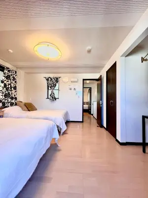 a hotel room with two beds and a hallway at Dragon\u4e09\u5c42\u522b\u5885 \u65b0\u5bbf \u6da9\u8c37 \u4e0a\u91ce\u5546\u5708 \u5c71\u624b\u7ebf\u8f66\u7ad98\u5206\u949f \u4ea4\u901a\u4fbf\u5229 in Tokyo