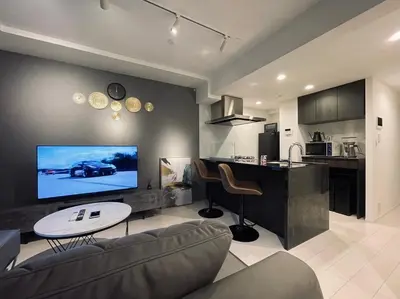 a living room with a couch and a tv on a wall at Alo BnB 9 - Near ROPPONGI, GINZA, SHINJUKU, SHIBUYA - Self check-in in Tokyo