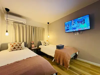 a room with two beds and a tv on the wall at Shinjuku Kabukichō-4F-SJ0013 in Tokyo