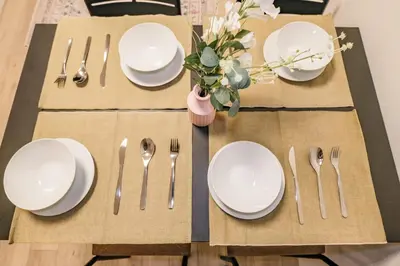a table set with white plates and forks and knives at Apb \u4e24\u56fd in Tokyo