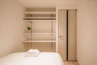 a room with a bed and a closet with towels at Apb \u4e24\u56fd in Tokyo