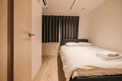 a small bedroom with a bed and a window at Apb \u4e24\u56fd in Tokyo