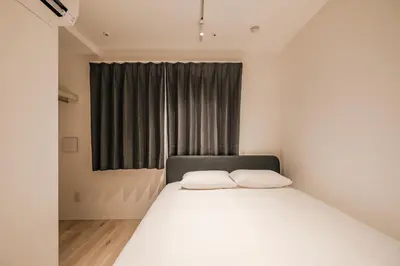 a bedroom with a white bed and a window at Apb \u4e24\u56fd in Tokyo