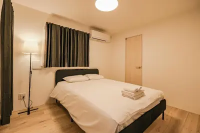 a bedroom with a bed with two towels on it at Apb \u4e24\u56fd in Tokyo