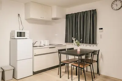 a small kitchen with a black table and chairs at Apb \u4e24\u56fd in Tokyo