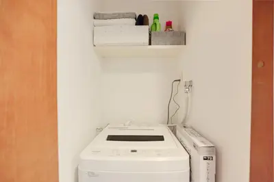 a washer and dryer in a room with a wall at Luna House in Tokyo