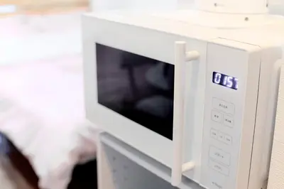 a white microwave oven sitting on top of a counter at Luna House in Tokyo