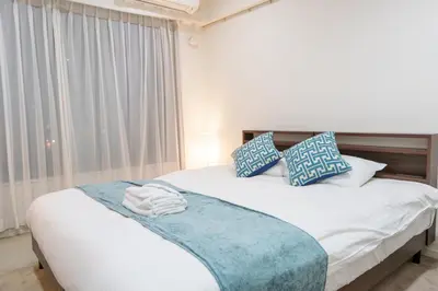 a bedroom with a bed with blue and white pillows at Pangoo Shinagawa Room 104 - Vacation STAY 97800v in Tokyo