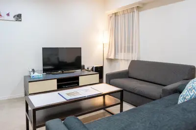 a living room with a couch and a flat screen tv at Pangoo Shinagawa Room 104 - Vacation STAY 97800v in Tokyo
