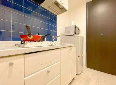 a white kitchen with a red pot on a stove at Pangoo Shinagawa Room 202 - Vacation STAY 98591v in Tokyo