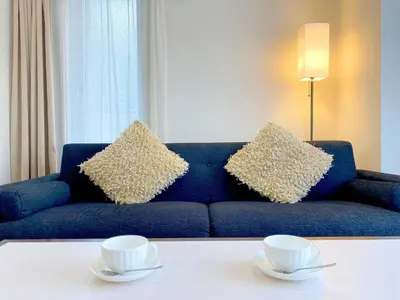 a blue couch with two cups on a table at Pangoo Shinagawa Room 304 - Vacation STAY 18366 in Tokyo