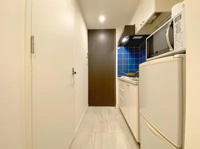 a kitchen with a white refrigerator and a microwave at Pangoo Shinagawa Room 304 - Vacation STAY 18366 in Tokyo
