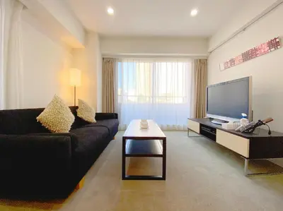 a living room with a black couch and a flat screen tv at Pangoo Shinagawa Room 304 - Vacation STAY 18366 in Tokyo