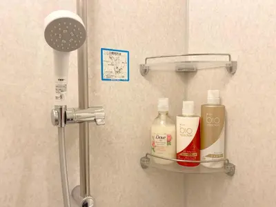 a bathroom with a shelf with bottles of soap and a shower at Pangoo Shinagawa Room 402 - Vacation STAY 99354v in Tokyo