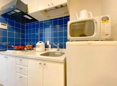 a kitchen with a sink and a microwave on top of a refrigerator at Pangoo Shinagawa Room 405 - Vacation STAY 18374 in Tokyo