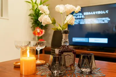 a bottle of whiskey and glasses on a table with a candle at \u5168\u65b0\u4e09\u4e4b\u8f6e\u8c6a\u534e\u4e00\u6237\u5efaa\u680b in Tokyo