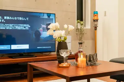 a coffee table with flowers and candles and a television at \u5168\u65b0\u4e09\u4e4b\u8f6e\u8c6a\u534e\u4e00\u6237\u5efaa\u680b in Tokyo