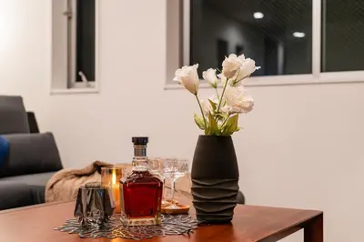 a table with a vase of flowers and a bottle of alcohol at \u5168\u65b0\u4e09\u4e4b\u8f6e\u8c6a\u534e\u4e00\u6237\u5efaa\u680b in Tokyo
