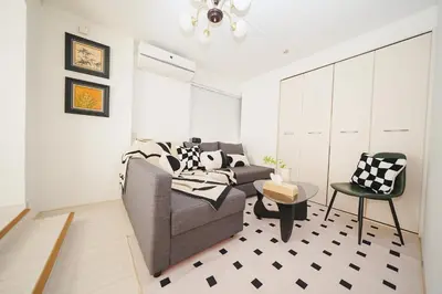 a living room with a couch and a chair at Panda Style 3-story 9ppl House FreeParking 3br&tub in Tokyo
