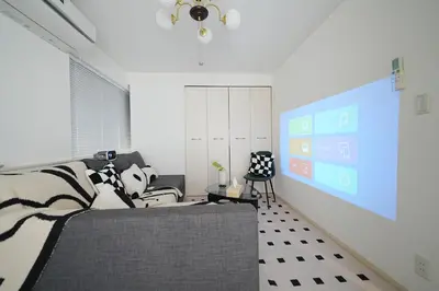 a living room with a couch and a large screen at Panda Style 3-story 9ppl House FreeParking 3br&tub in Tokyo