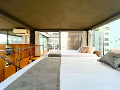 a bedroom with two beds and a balcony at Natsumezaka Room3 NM3 in Tokyo
