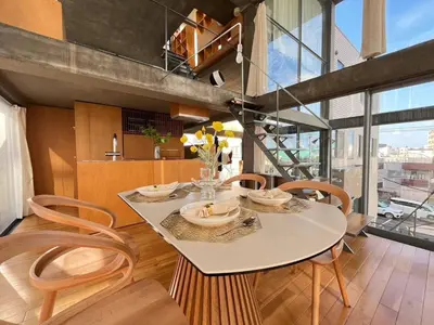 a dining room with a table and chairs and a staircase at Natsumezaka Room3 NM3 in Tokyo