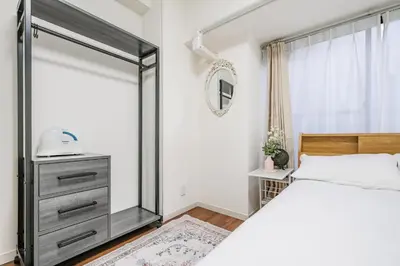 a bedroom with a bed and a mirror at Ikebukuro La Rêve House in Tokyo