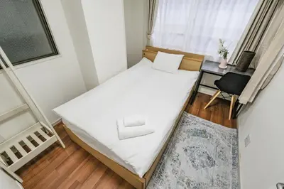 a small bedroom with a bed and a desk at Ikebukuro La Rêve House in Tokyo