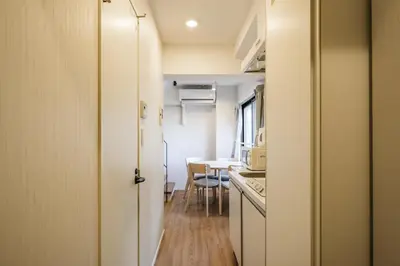 a kitchen and dining room with a table and a door at Mi-HOTEL ASAKUSA in Tokyo