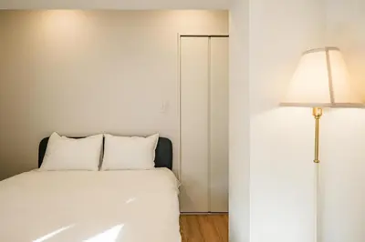 a bedroom with a white bed and a lamp at Mi-HOTEL ASAKUSA in Tokyo