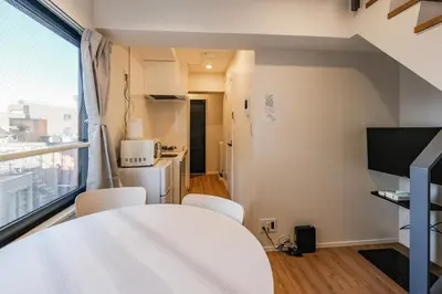 a room with a table and chairs and a kitchen at Mi-HOTEL ASAKUSA in Tokyo