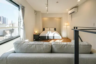 a living room with a couch and a bed at Mi-HOTEL ASAKUSA in Tokyo