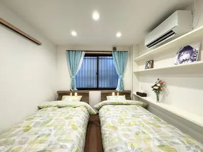 two beds in a room with a window at sun inn in Tokyo