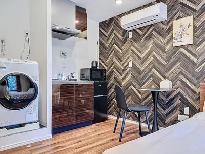 a kitchen with a washing machine and a table in a room at Senzoku 1 Chome in Tokyo