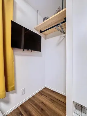 a living room with a flat screen tv on a wall at Senzoku 1 Chome in Tokyo