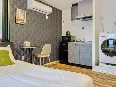 a bedroom with a bed and a table and a kitchen at Senzoku 1 Chome in Tokyo
