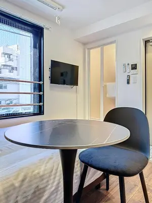 a table and a chair in a room with a tv at Senzoku 1 Chome in Tokyo