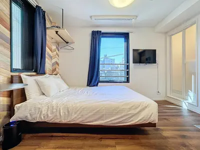 a bedroom with a large bed with a window at Senzoku 1 Chome in Tokyo