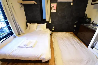 two beds in a hotel room with towels on them at Senzoku 1 Chome in Tokyo