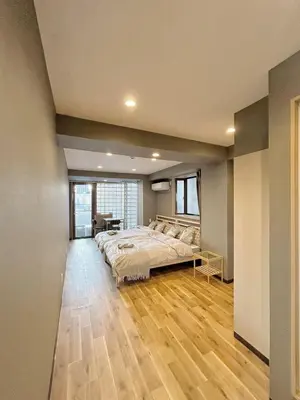 a bedroom with a large bed and a wooden floor at \u6d45\u8349\u30b9\u30ab\u30a4\u30ac\u30fc\u30c7\u30f3\u30db\u30c6\u30eb in Tokyo