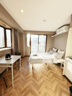 a bedroom with a bed and a table in it at \u6d45\u8349\u30b9\u30ab\u30a4\u30ac\u30fc\u30c7\u30f3\u30db\u30c6\u30eb in Tokyo