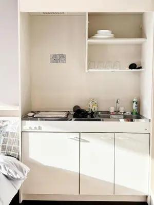 a kitchen with white cabinets and a sink at \u6d45\u8349\u30b9\u30ab\u30a4\u30ac\u30fc\u30c7\u30f3\u30db\u30c6\u30eb in Tokyo