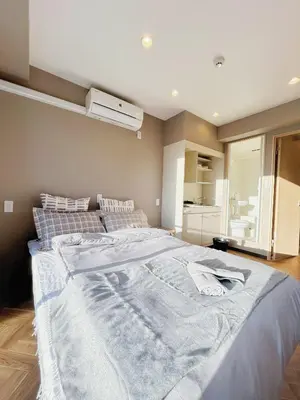 a bedroom with a large bed with a white blanket at \u6d45\u8349\u30b9\u30ab\u30a4\u30ac\u30fc\u30c7\u30f3\u30db\u30c6\u30eb in Tokyo