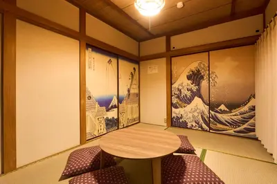 a room with a table and chairs and paintings at Paradiso\u9752\u6238 in Tokyo
