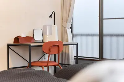 a desk with a computer and a chair next to a window at Paradiso\u9752\u6238 in Tokyo