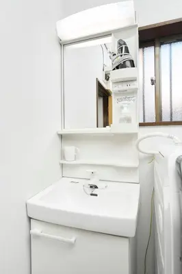 a white bathroom with a sink and a mirror at Paradiso\u9752\u6238 in Tokyo