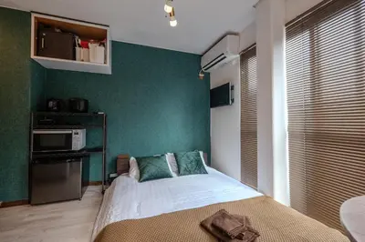 a bedroom with a bed and a green wall at #16 -\u65b0\u9ad8\u5186\u5bfa \u30e1\u30be\u30f3\u30e2\u30ea\u30bf- Studio in Tokyo